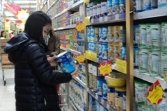 Người tiêu dùng lựa chọn mặt hàng sữa. (Ảnh: PV/Vietnam+)