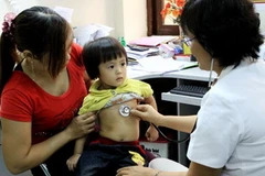 Cán bộ dinh dưỡng tư vấn về dinh dưỡng cho trẻ em. (Ảnh: TTXVN)