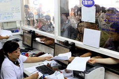 Nhân viên y tế làm các thủ tục cho người khám bệnh. (Ảnh: Dương Ngọc/TTXVN)