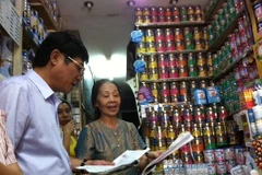 Cục trưởng Cục An toàn Thực phẩm kiểm tra các giấy tờ về việc thu hồi thức ăn công thức cho trẻ. (Ảnh: Thùy Giang/Vietnam+)