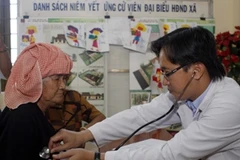 Bác sỹ khám bệnh cho người dân. (Ảnh: TTXVN)