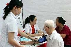 Các bác sỹ khám bệnh cho người già. (Ảnh: TTXVN)