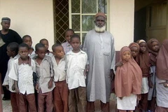 Cụ ông Barinjimi (giữa) chụp ảnh với "các bạn" cùng lớp. (Ảnh: AFP/TTXVN) 