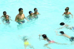 Để phòng bệnh amip ăn não người, khi tắm ở bơi bể bơi người dân cần hạn chế nước vào mũi. (Ảnh: TTXVN)