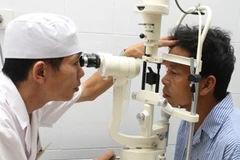 Bác sỹ khám cho các bệnh nhân đau mắt đỏ. (Ảnh: Anh Tuấn/TTXVN)