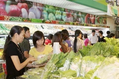 Người dân mua sắm hàng hóa tại siêu thị. (Ảnh: Trần Việt/TTXVN)