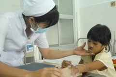 Bác sỹ chăm sóc cho trường hợp trẻ bị hở môi. (Ảnh: Thanh Vũ/TTXVN)