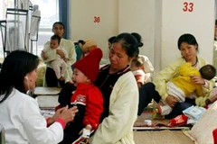 Bác sỹ khám bệnh cho trẻ. (Ảnh: TTXVN)