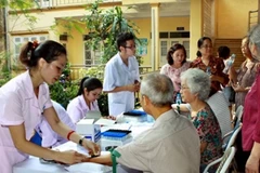 Cán bộ y tế khám chữa bệnh cho người cao tuổi. (Ảnh: Dương Ngọc/TTXVN)