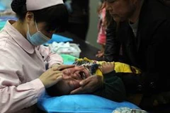 Điều trị cho một em nhỏ bị cúm tại Trung Quốc. (Ảnh: AFP/TTXVN)