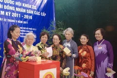 Cử tri nữ phường Hàng Đào thướt tha trong tà áo dài đi bầu cử. (Ảnh: Thùy Giang/Vietnam+)