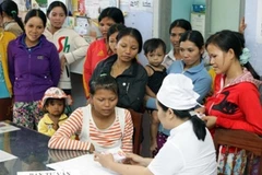 Nhân viên y tế tư vấn, cung cấp dịch vụ chăm sóc sức khỏe sinh sản cho phụ nữ dân tộc Ba Na. (Ảnh: Dương Ngọc/TTXVN)