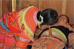 Cô đỡ thôn bản đang khám thai cho một sản phụ. (Ảnh: Vietnam+)