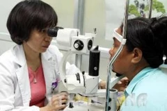 Bác sỹ khám mắt cho bệnh nhân ở Bệnh viện mắt Hà Nội. (Ảnh: Hữu Oai/TTXVN)