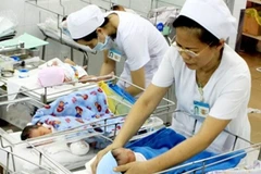 Nhân viên y tế chăm sóc cho trẻ sơ sinh. (Ảnh minh họa: Dương Ngọc/TTXVN)