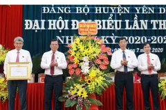 Bí thư Tỉnh ủy Bắc Giang Bùi Văn Hải (thứ 2 từ phải sang) tặng hoa chúc mừng và trao Bằng khen của Ban thường vụ Tỉnh ủy cho Đảng bộ huyện Yên Dũng. (Ảnh: Đồng Thúy/TTXVN)