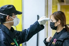 Kiểm tra thân nhiệt để phòng chống dịch virus corona. (Nguồn: EPA)