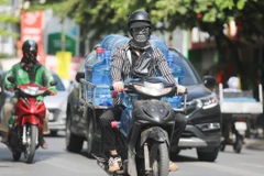 Thời tiết nắng nóng, người dân cần trang bị tốt đồ bảo hộ khi ra đường để bảo vệ sức khỏe. (Ảnh: Thanh Tùng/TTXVN)