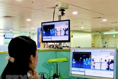 Nhân viên sân bay Tân Sơn Nhất kiểm tra màn hình hiển thị máy quét thân nhiệt đối với hành khách quốc tế đến Việt Nam. (Ảnh: Đinh Hằng/TTXVN) 