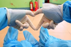 Sự lạc quan, yêu đời giúp các thanh niên tình nguyện không thấy mệt mỏi khi làm việc tại khu cách ly. (Ảnh: TTXVN phát)