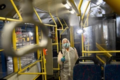 Nhân viên phun thuốc khử trùng trên xe điện nhằm ngăn chặn lây lan của COVID-19 tại Kiev, Ukraine. (Ảnh: AFP/TTXVN)