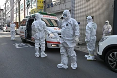 Nhân viên y tế Hàn Quốc làm nhiệm vụ tại một khu dân cư ở thành phố Daegu, nơi phát hiện các trường hợp có triệu trứng nhiễm virus SARS-CoV-2, ngày 27/2. (Ảnh: AFP/TTXVN)