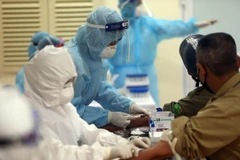 Lấy mẫu xét nghiệm bệnh COVID-19 cho người dân. (Ảnh: TTXVN)