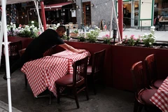 Nhân viên sửa soạn lại bàn ghế tại một nhà hàng ở New York, Mỹ. (Ảnh: AFP/TTXVN)