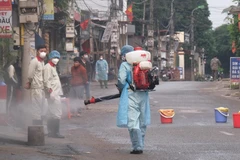 Lực lượng chức năng phun khử khuẩn. (Ảnh: Phạm Hùng/TTXVN phát)