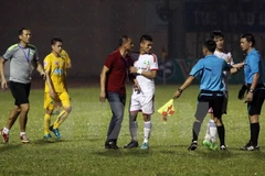 HLV Ngô Quang Trường phản ứng trọng tài vì quyết định thổi phạt penalty. (Ảnh: Thanh Tùng/TTXVN)