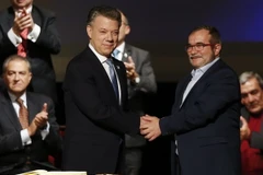 Tổng thống Colombia Juan Manuel Santos (trái, trước) và Thủ lĩnh tối cao FARC Rodrigo Londono Echeverri sau lễ ký Thỏa thuận hòa bình sửa đổi ở Bogota ngày 24/11. (Nguồn: AP/TTXVN)