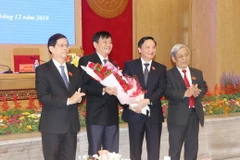 Ông Nguyễn Khắc Định, Bí thư Tỉnh ủy Khánh Hòa (người thứ 2 từ bên phải sang) tặng hoa chúc mừng ông Trần Mạnh Dũng. (Ảnh: Tiên Minh/TTXVN)