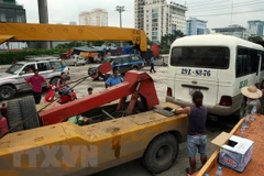 Di chuyển xe vi phạm tại một bến cóc ở khu vực gần bến xe Mỹ Đình. (Ảnh: Huy Hùng/TTXVN)