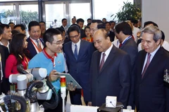 Thủ tướng Nguyễn Xuân Phúc tham quan các gian hàng triển lãm tại Diễn đàn Quốc gia nâng tầm kỹ năng lao động Việt Nam. (Ảnh: Thống Nhất/TTXVN)