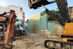 Trong quá trình thi công khách sạn, cần cẩu gặp trục trặc khiến cần khoan đổ sập vào nhà dân. (Ảnh: Nguyên Linh/TTXVN)