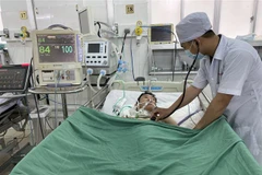 Bác sỹ kiểm tra cho bệnh nhân sau can thiệp. (Ảnh: TTXVN)