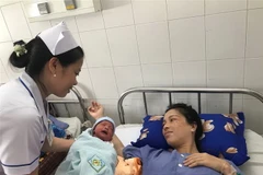 Hai mẹ con sản phụ sau phẫu thuật. (Ảnh: TTXVN)
