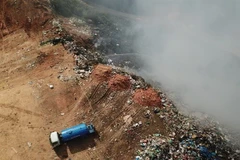 Đưa xe chứa nước vào dập lửa. (Ảnh: Đặng Tuấn/TTXVN)