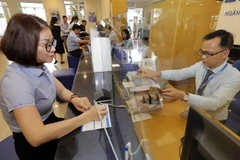 Khách hàng giao dịch tại Ngân hàng Bảo Việt chi nhánh Gia Lai. (Ảnh: Trần Việt/TTXVN)