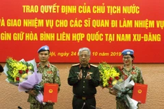 Thượng tướng Nguyễn Chí Vịnh, Thứ trưởng Bộ Quốc phòng, Trưởng Ban Chỉ đạo Bộ Quốc phòng trao Quyết định của Chủ tịch nước cho 2 sỹ quan tham gia hoạt động gìn giữ hòa bình Liên hợp quốc tại Nam Sudan. (Ảnh: Nguyễn Dân/TTXVN)
