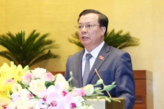 Bộ trưởng Bộ Tài chính Đinh Tiến Dũng trình bày Tờ trình về dự thảo Nghị quyết về khoanh tiền nợ thuế, xóa tiền phạt chậm nộp, tiền chậm nộp đối với người nộp thuế không còn khả năng nộp ngân sách nhà nước. (Ảnh: Phương Hoa/TTXVN)