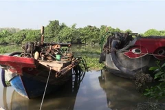 Ghe hút cát lậu tại hiện trường. (Ảnh: Nguyễn Văn Việt/TTXVN)