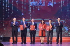 Trưởng ban Tuyên giáo Trung ương Võ Văn Thưởng và Bộ trưởng Bộ Thông tin và Truyền thông Nguyễn Mạnh Hùng trao giải A cho các tác giả đoạt giải. (Ảnh: Minh Quyết/TTXVN)