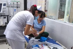 Công nhân Công ty TNHH Theodore Alexander được điều trị tại Bệnh viện Đa khoa quận Thủ Đức với các triệu chứng nghi ngộ độc thực phẩm. (Ảnh: TTXVN)