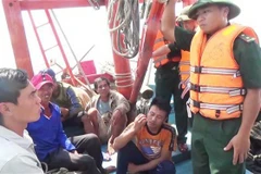 Cán bộ, chiến sỹ biên phòng Quảng Bình trò chuyện, thăm hỏi tình hình các thuyền viên tàu bị nạn. (Ảnh: Châu Thành/TTXVN)