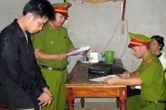 Công an huyện Cam Lộ, Quảng Trị đọc lệnh bắt đối tượng chống người thi hành công vụ. (Ảnh: Hồ Cầu/TTXVN)