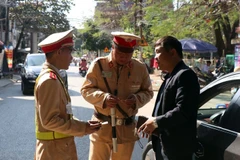 Lực lượng cảnh sát giao thông tỉnh Cà Mau kiểm tra nồng độ cồn của người tham gia giao thông (ảnh chụp đêm 5/1). (Ảnh: Huỳnh Thế Anh/TTXVN)