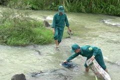 Dân quân tự vệ huyện miền núi Ngọc Lặc, tỉnh Thanh Hóa xuống sông, suối thu gom rác thải để hạn chế ô nhiễm môi trường. (Ảnh: Nguyễn Nam/TTXVN)
