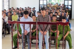 Hai bị cáo Quang và Tý trước vành móng ngựa. (Ảnh: Công Thử/TTXVN)