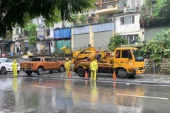 Công nhân Công ty TNHH MTV Thoát nước Hà Nội huy động phương tiện cơ giới ứng trực thưc hiện nhiệm vụ tiêu thoát nước tại các điểm nguy cơ úng ngập. (Ảnh TTXVN phát)